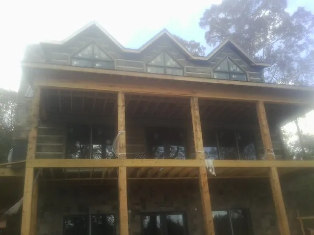 Dormers and porch framing on a large log home under construction — Roof Coating work by our crew in Towaco