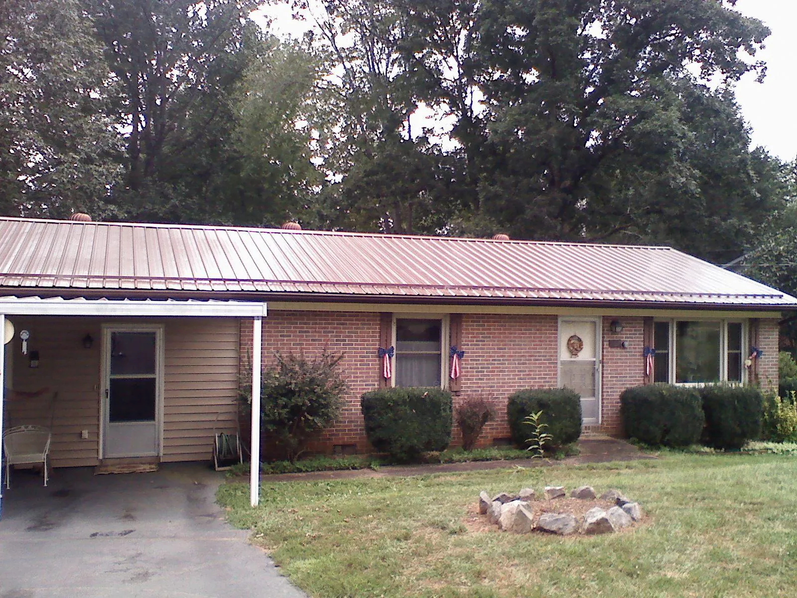 Bronze metal roof and carport on a brick ranch home — Roof Repair work by our crew in Towaco